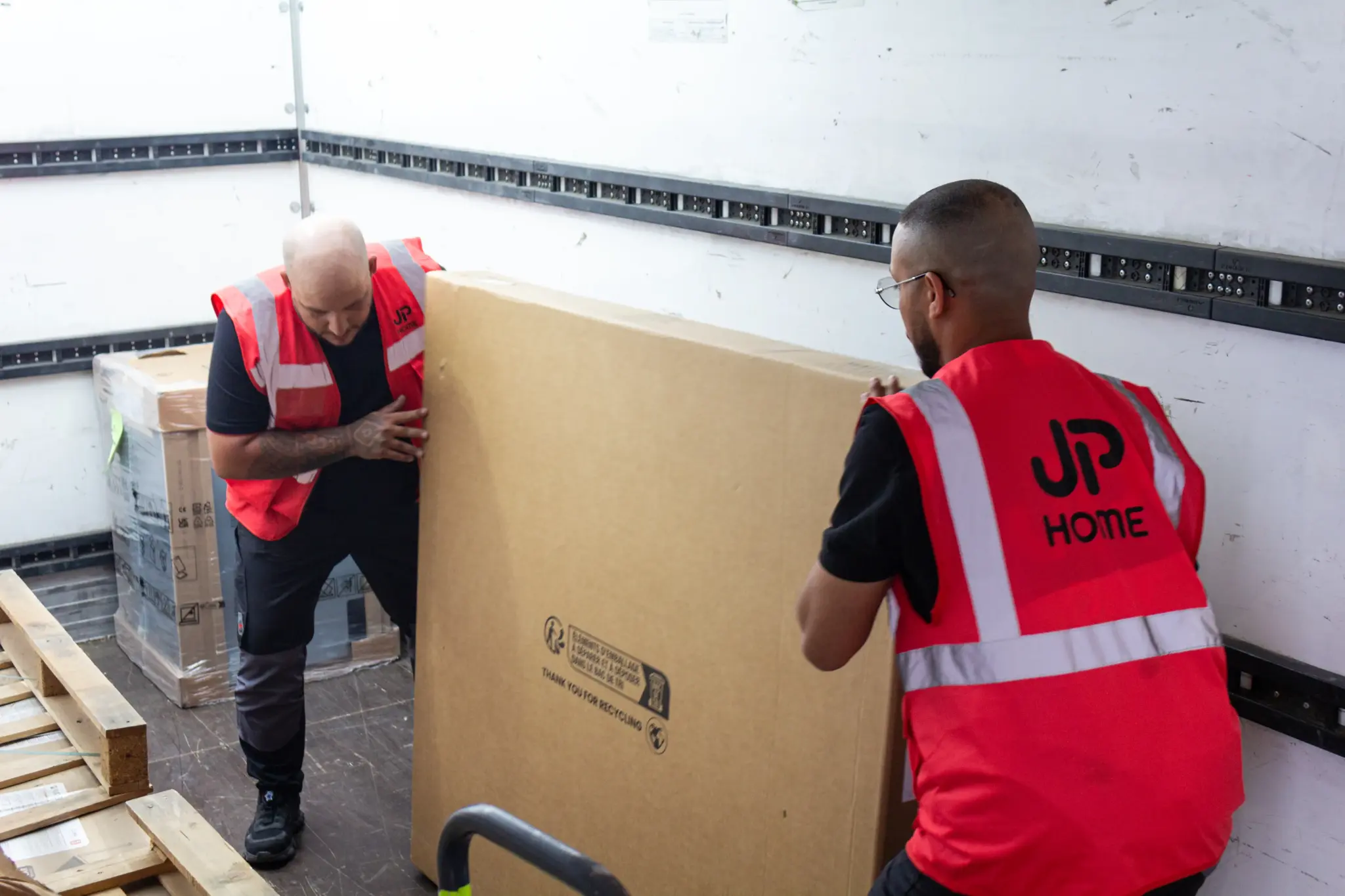 deux livreurs JP HOME apporte un gros colis