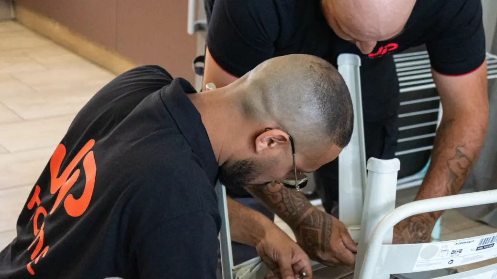 Deux hommes assemblent une chaise blanche en suivant la notice IKEA