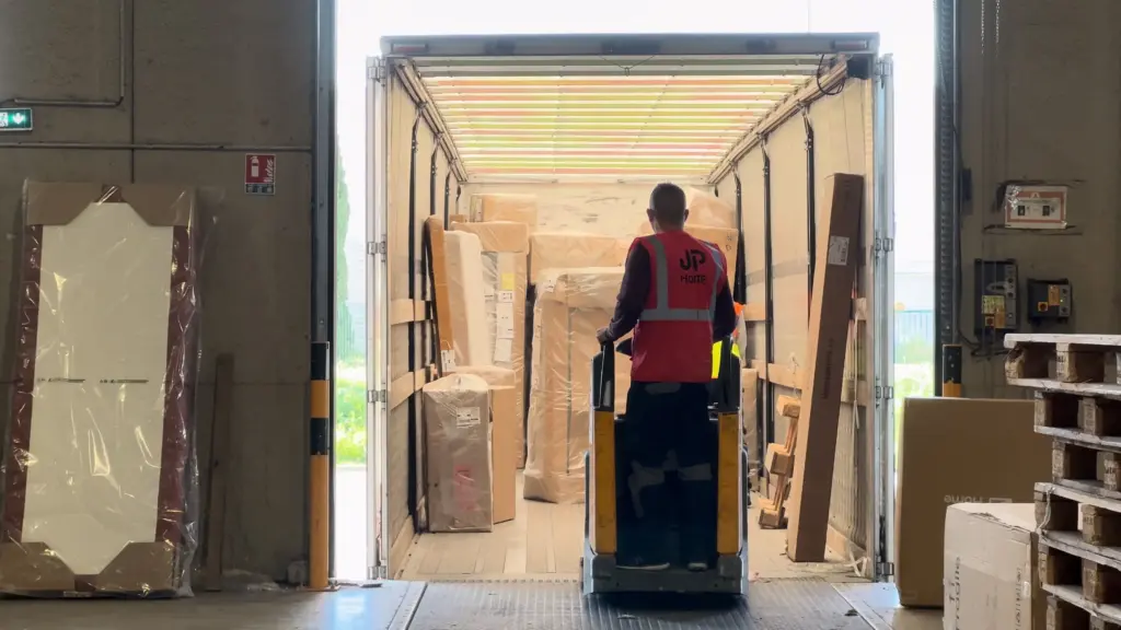 Chariot élévateur transportant des meubles emballés dans un camion de livraison ouvert